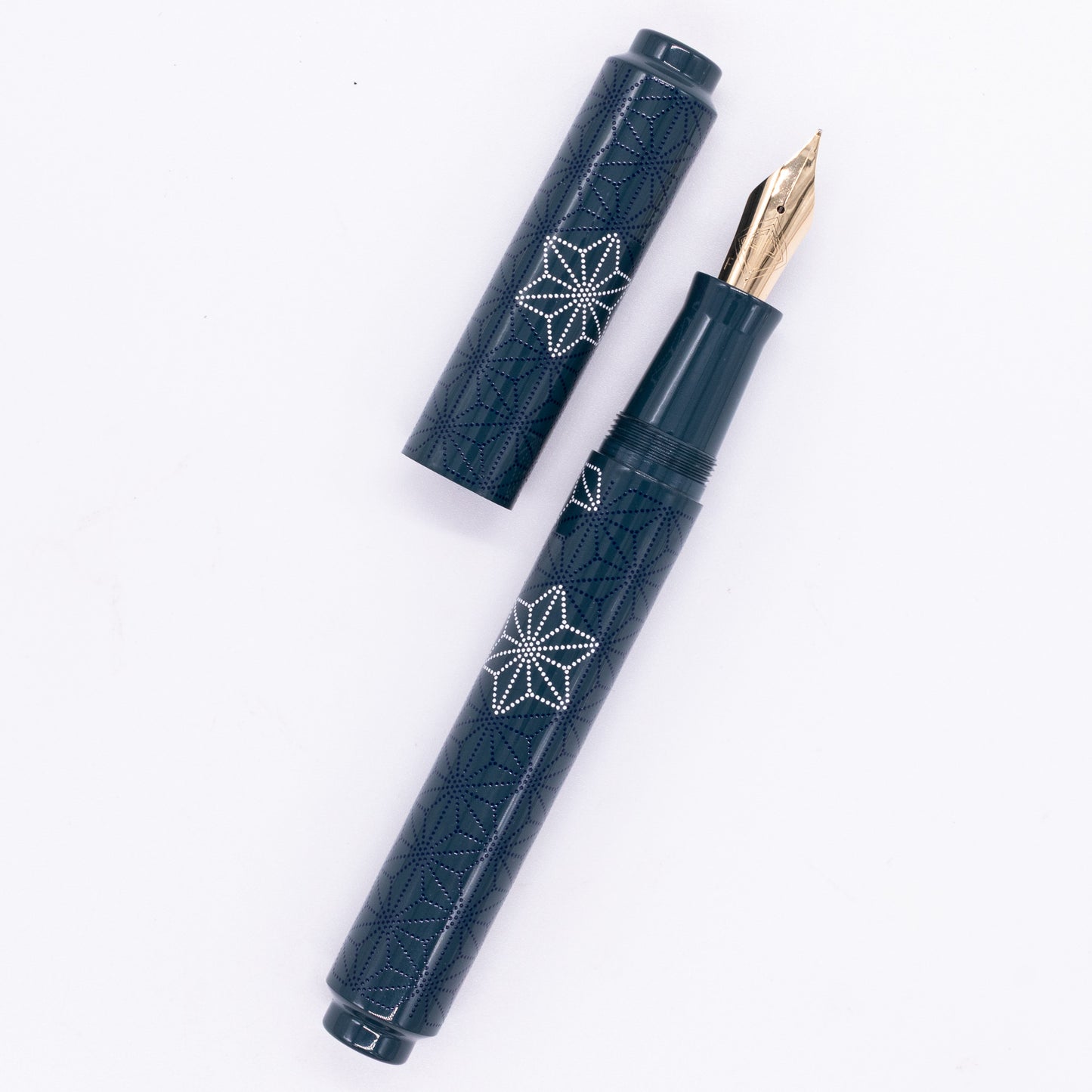 An overhead view of the AP Limited Editions Sakura Lacquer Art Fountain Pen - Snowflakes Blue uncapped, with the cap next to the body angled towards the right.