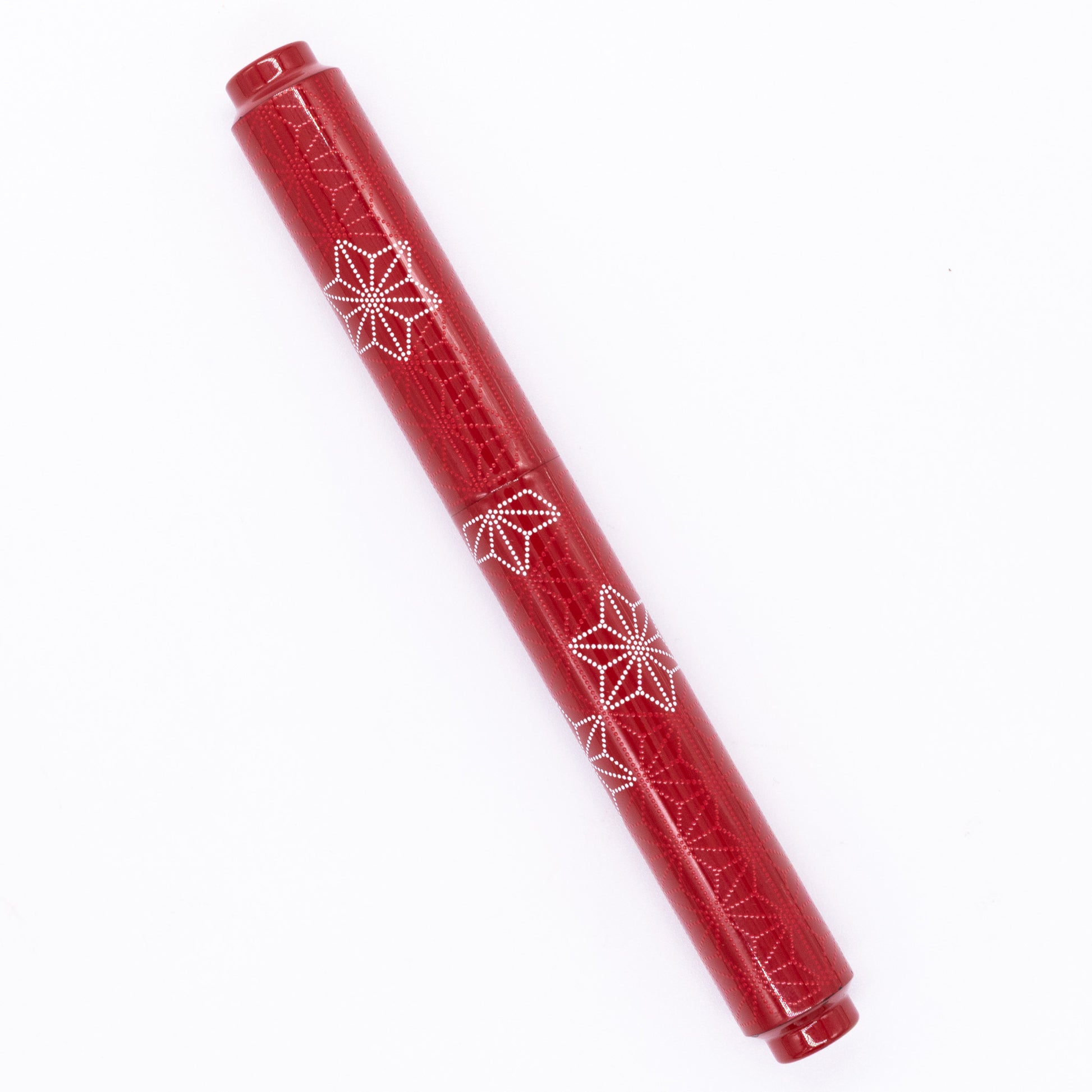 An overhead view of the AP Limited Editions Sakura Lacquer Art Fountain Pen - Snowflakes Red capped, angled towards the left.