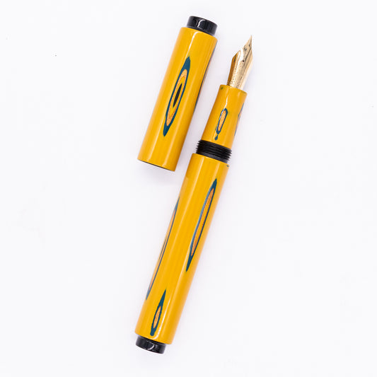  An overhead view of the AP Limited Editions Urushi Lacquer Art Fountain Pen - Amorphous Splendour Yellow uncapped, with the cap next to the body angled towards the right.