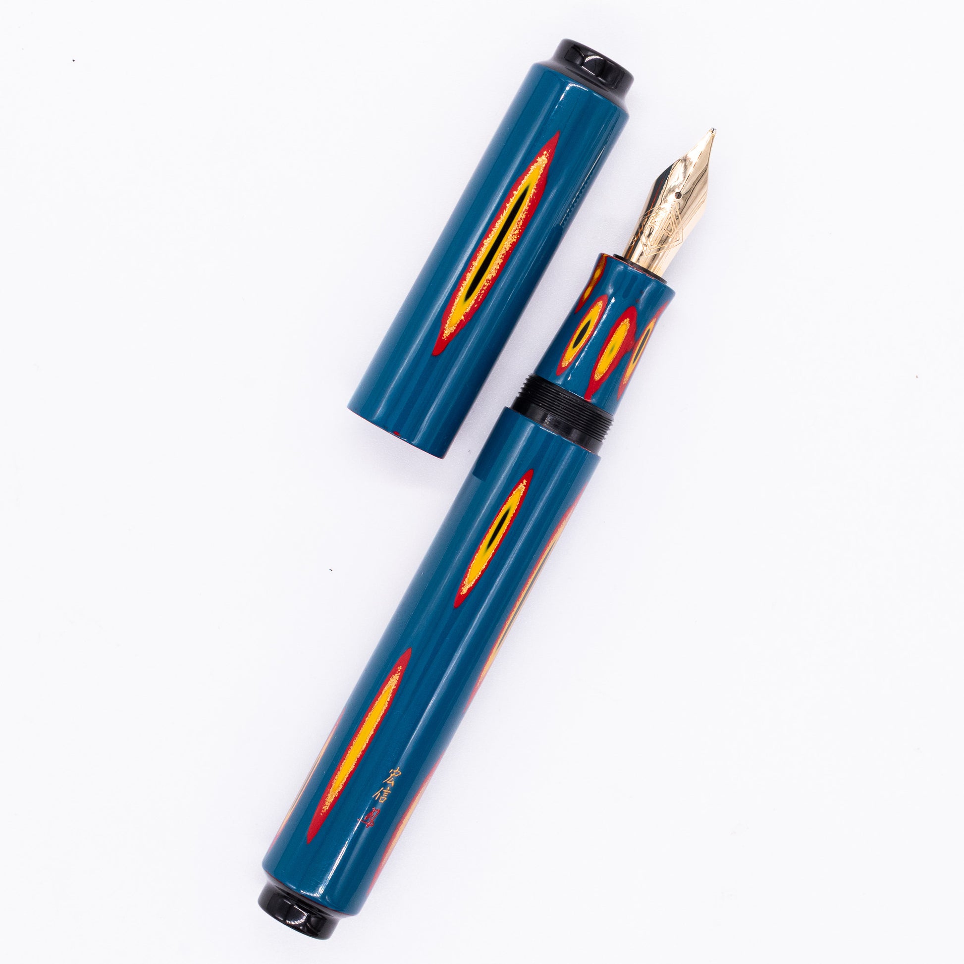 An overhead view of the AP Limited Editions Urushi Lacquer Art Fountain Pen - Amorphous Splendour (Blue) uncapped, with the cap next to the body angled towards the right.