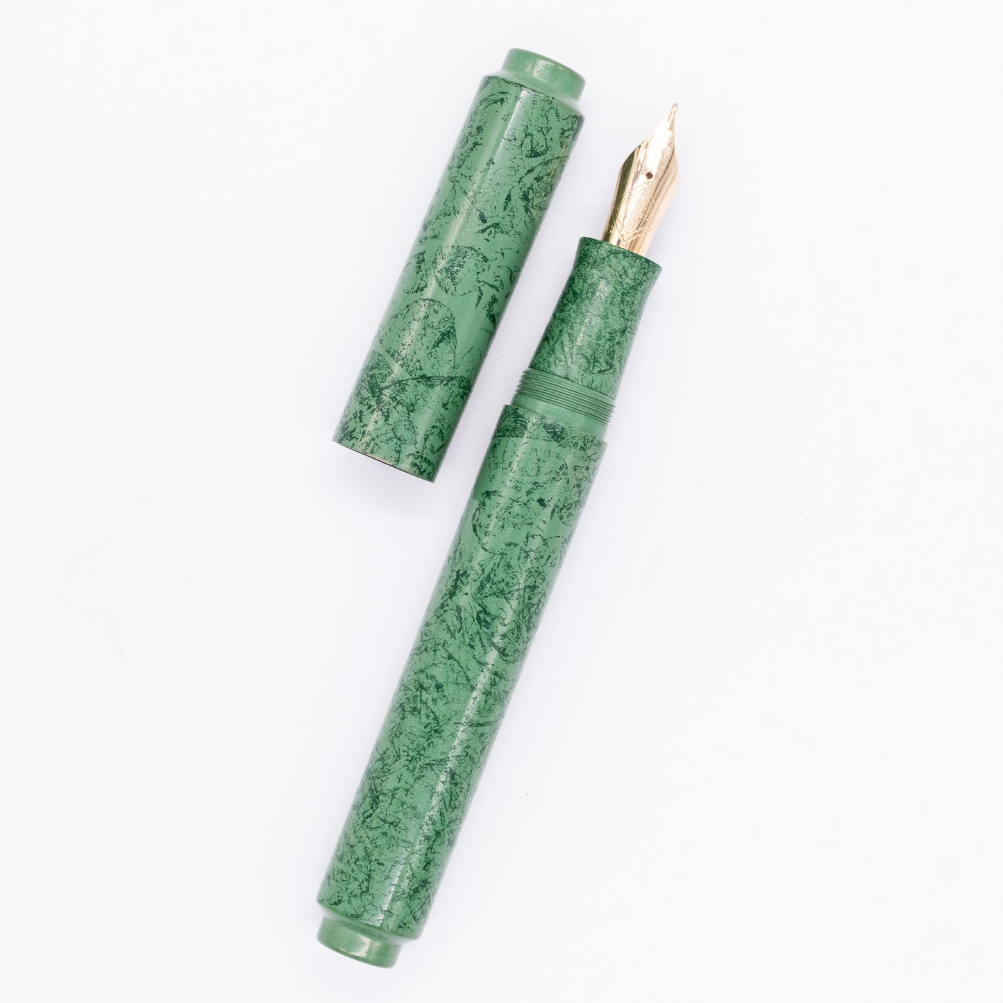 An overhead view of the AP Limited Editions Urushi Lacquer Art Fountain Pen - Celadon Moss uncapped, with the cap next to the body angled towards the right.