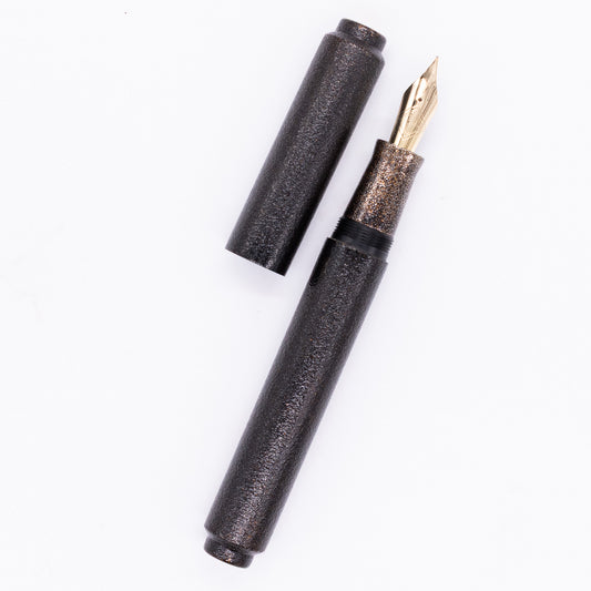 An overhead view of the AP Limited Editions Urushi Lacquer Art Fountain Pen - Colors of the Cosmos Interstellar uncapped, with the cap next to the body angled towards the right.