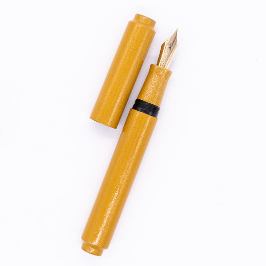 An overhead view of the AP Limited Editions Urushi Lacquer Art Fountain Pen - Colors of the Cosmos Solaris uncapped, with the cap next to the body angled towards the right.