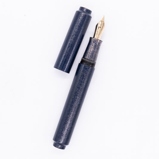 An overhead view of the AP Limited Editions Urushi Lacquer Art Fountain Pen - Colors of the Cosmos Spica uncapped, with the cap next to the body angled towards the right.