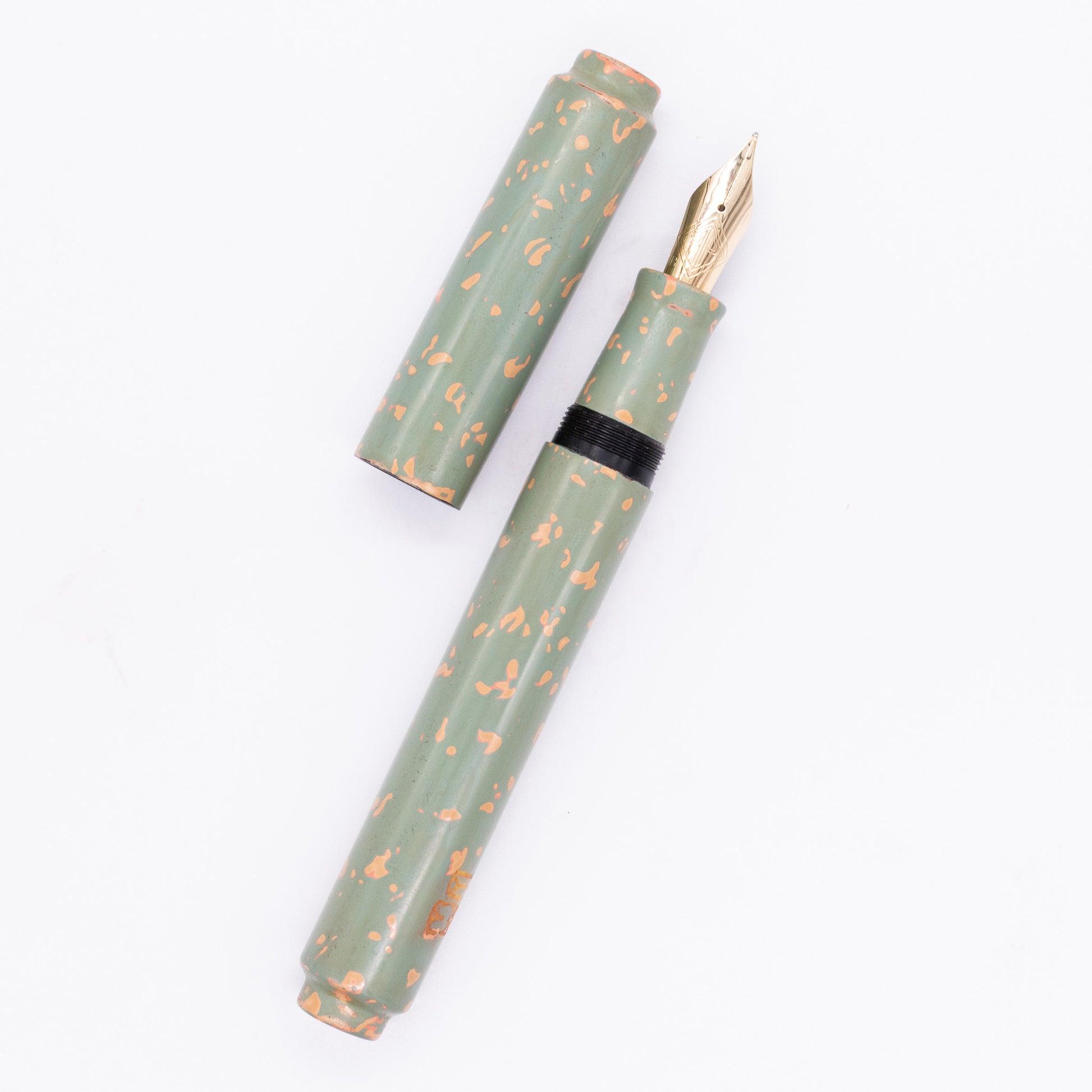 An overhead view of the AP Limited Editions Urushi Lacquer Art Fountain Pen - Garden Stone uncapped, with the cap next to the body angled towards the right.