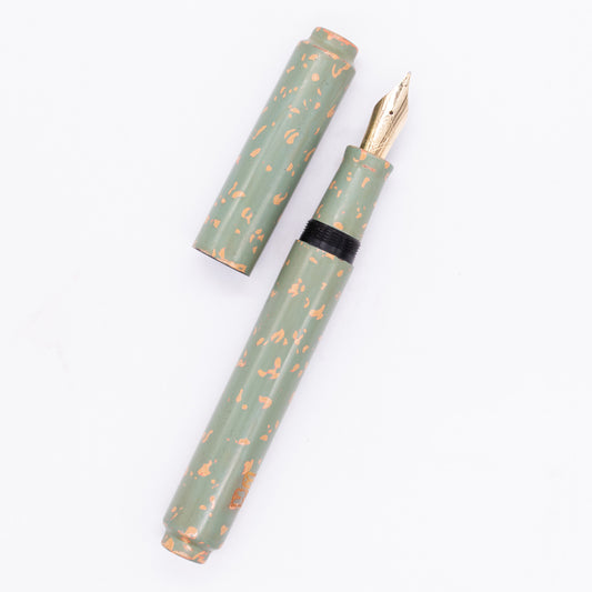 An overhead view of the AP Limited Editions Urushi Lacquer Art Fountain Pen - Garden Stone uncapped, with the cap next to the body angled towards the right.