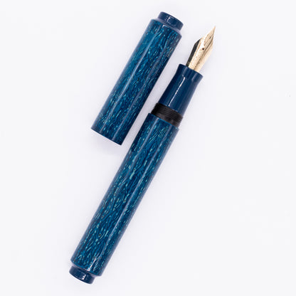 An overhead view of the AP Limited Editions Urushi Lacquer Art Fountain Pen - Midnight uncapped, with the cap next to the body angled towards the right.