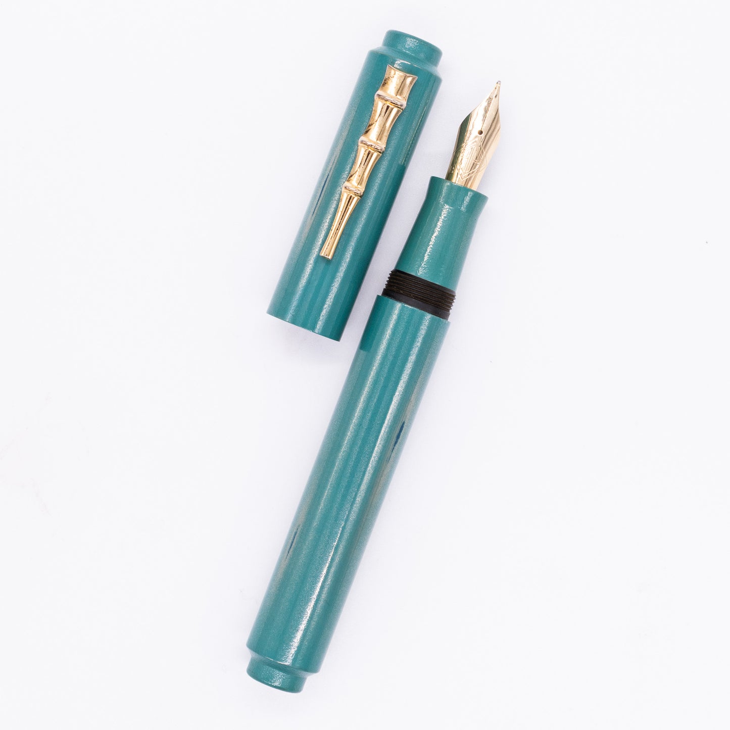 An overhead view of the AP Limited Editions Urushi Lacquer Art Fountain Pen - Proplyd Aqua (with Bamboo Clip) uncapped, with the cap next to the body angled towards the right.