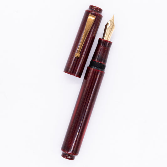 An overhead view of the AP Limited Editions Urushi Lacquer Art Fountain Pen - Proplyd Fire uncapped, with the cap next to the body angled towards the right.