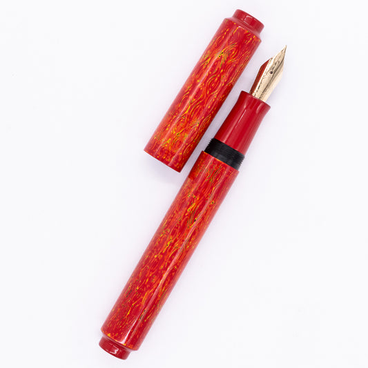 An overhead view of the AP Limited Editions Urushi Lacquer Art Fountain Pen - Red Earth uncapped, with the cap next to the body angled towards the right.