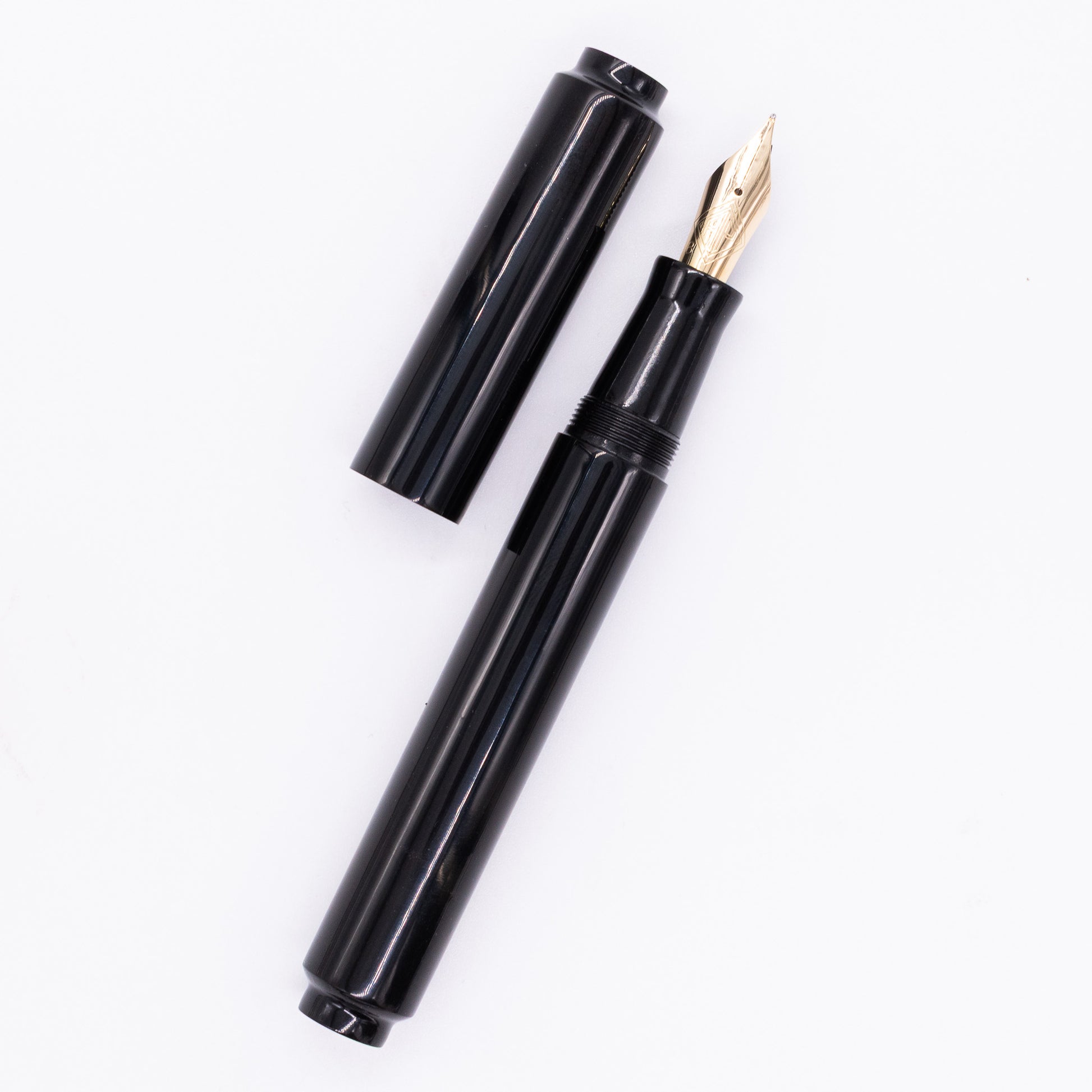 An overhead view of the AP Limited Editions Urushi Lacquer Art Fountain Pen - Roiro Black uncapped, with the cap next to the body angled towards the right.