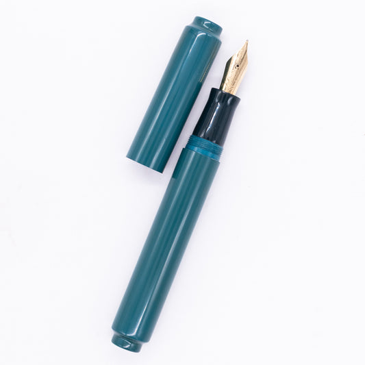 An overhead view of the AP Limited Editions Urushi Lacquer Art Fountain Pen - Seiheki Green uncapped, with the cap next to the body angled towards the right.