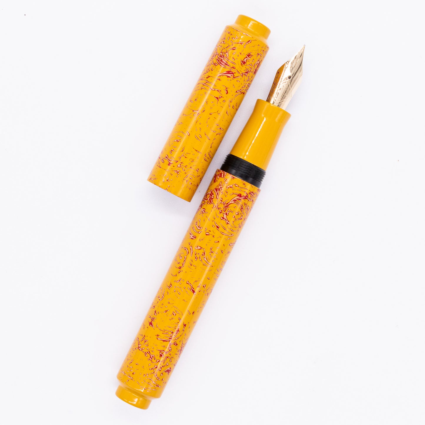 An overhead view of the AP Limited Editions Urushi Lacquer Art Fountain Pen - Sunshine uncapped, with the cap next to the body angled towards the right.