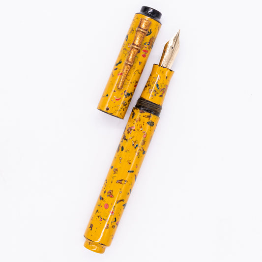 An overhead view of the AP Limited Editions Urushi Lacquer Art Fountain Pen - The Magical Urushi Yellow (with Bamboo Clip) uncapped, with the cap next to the body angled towards the right.