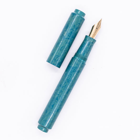 An overhead view of the AP Limited Editions Urushi Lacquer Art Fountain Pen - Tidal Stone uncapped, with the cap next to the body angled towards the right.