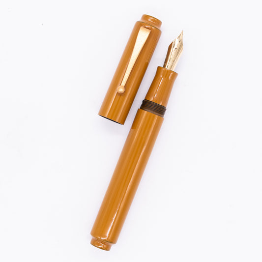 An overhead view of the AP Limited Editions Urushi Lacquer Art Fountain Pen - Yamabuki uncapped, with the cap next to the body angled towards the right.