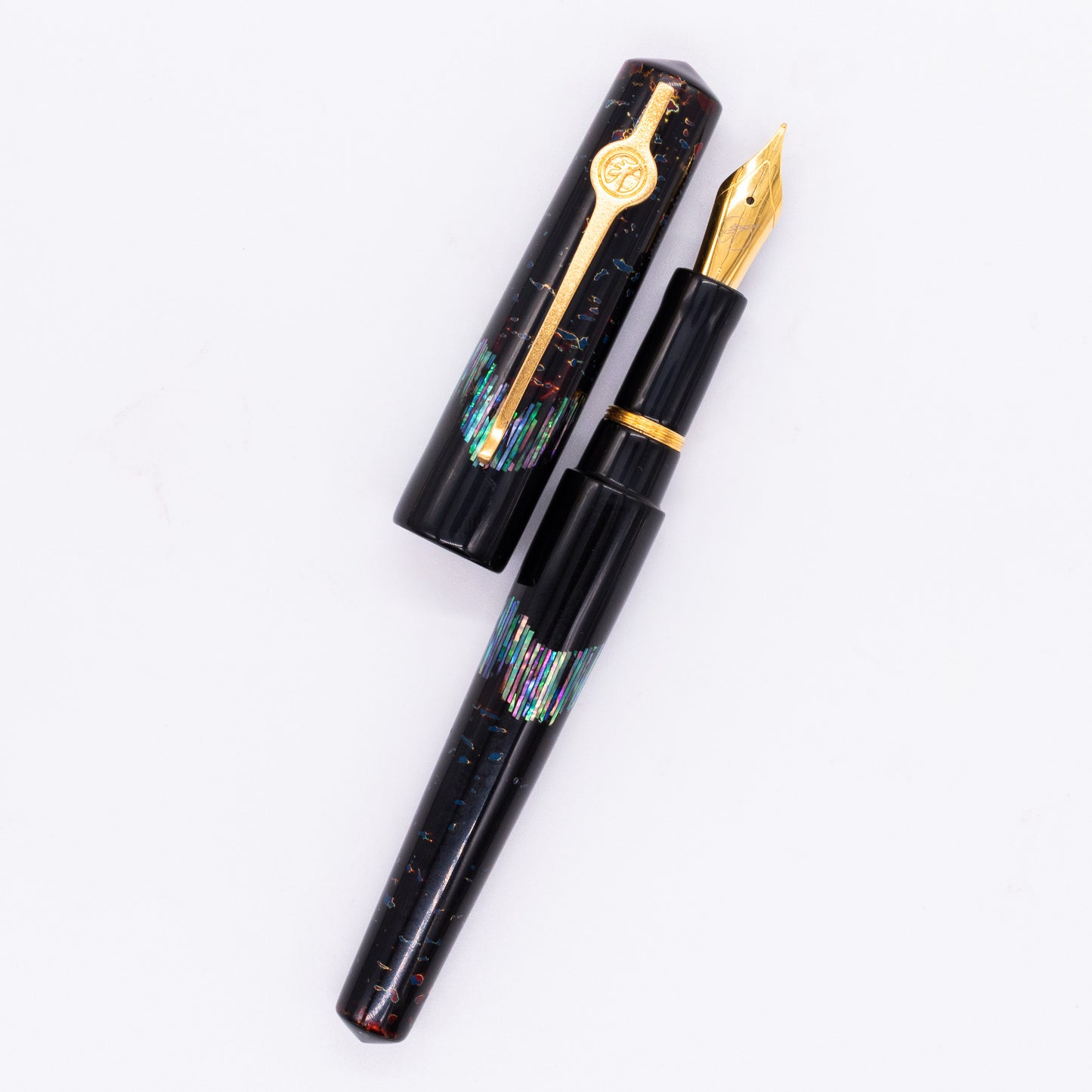 An overhead view of the ConCoPens Traditional Vietnamese Lacquer Fountain Pen - Ocean Serenade 2 uncapped, with the cap next to the body angled towards the right.